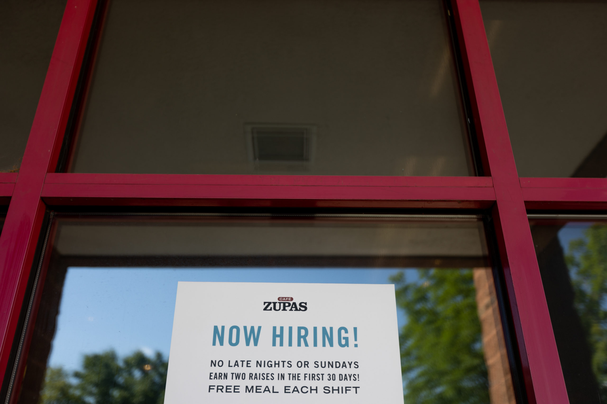 A Now Hiring sign hangs in the window of Zupas in Salt Lake City on Wednesday, July 20, 2022. (Ben ...