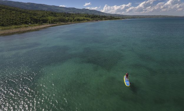 wide shot of Bear Lake with a person on a stand up paddle board