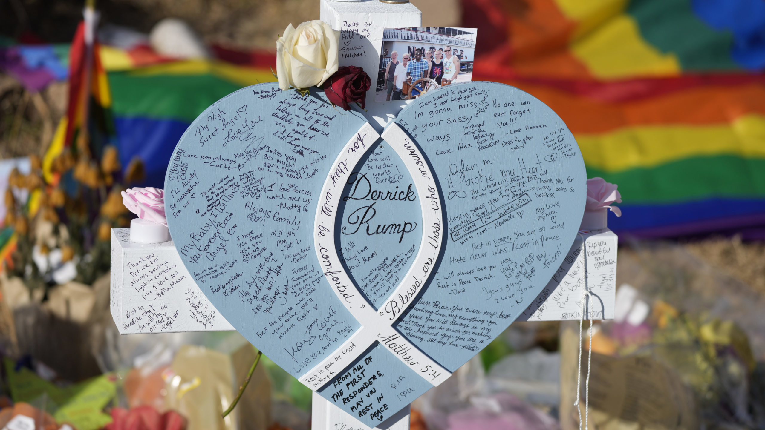 Hand-written messages cover the heart attached to the cross to honor a victim of the mass shooting ...