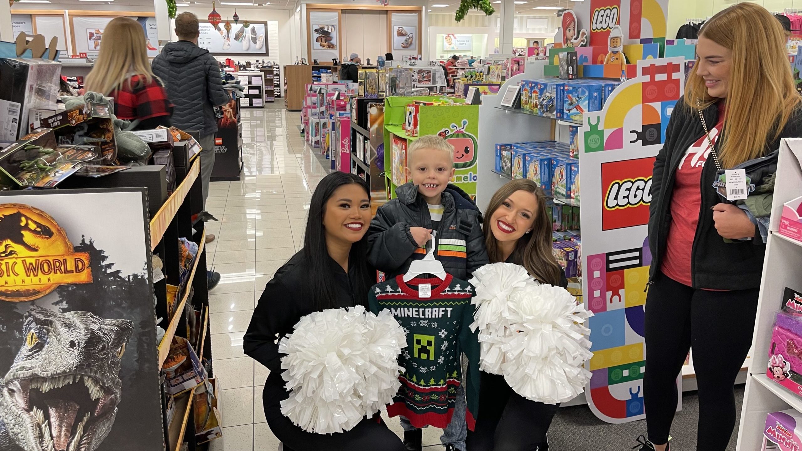 Two Jazz dancers pose with one of the Murray kids who was gifted a holiday shopping spree from Ken ...