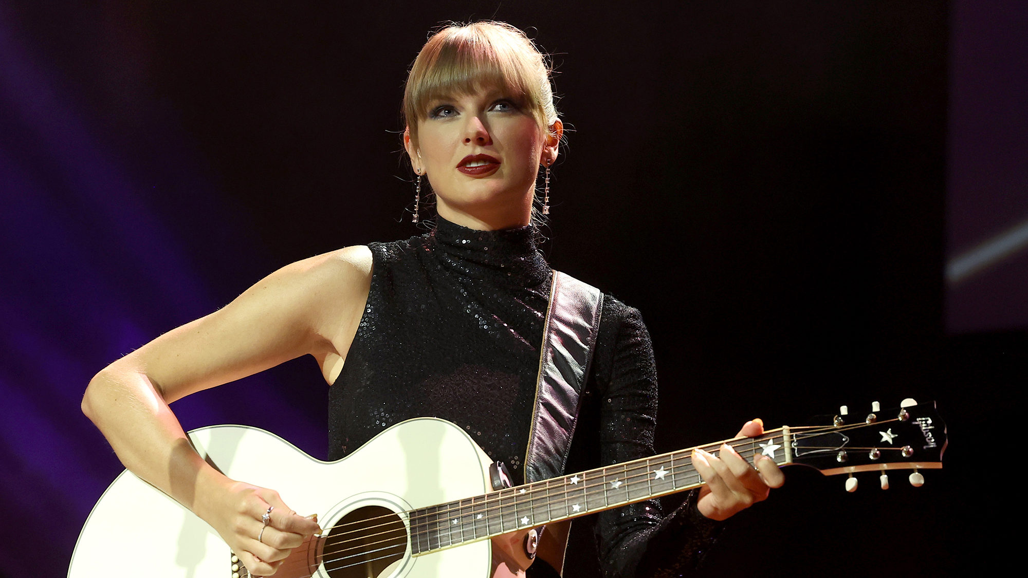 taylor swift is pictured playing a guitar...