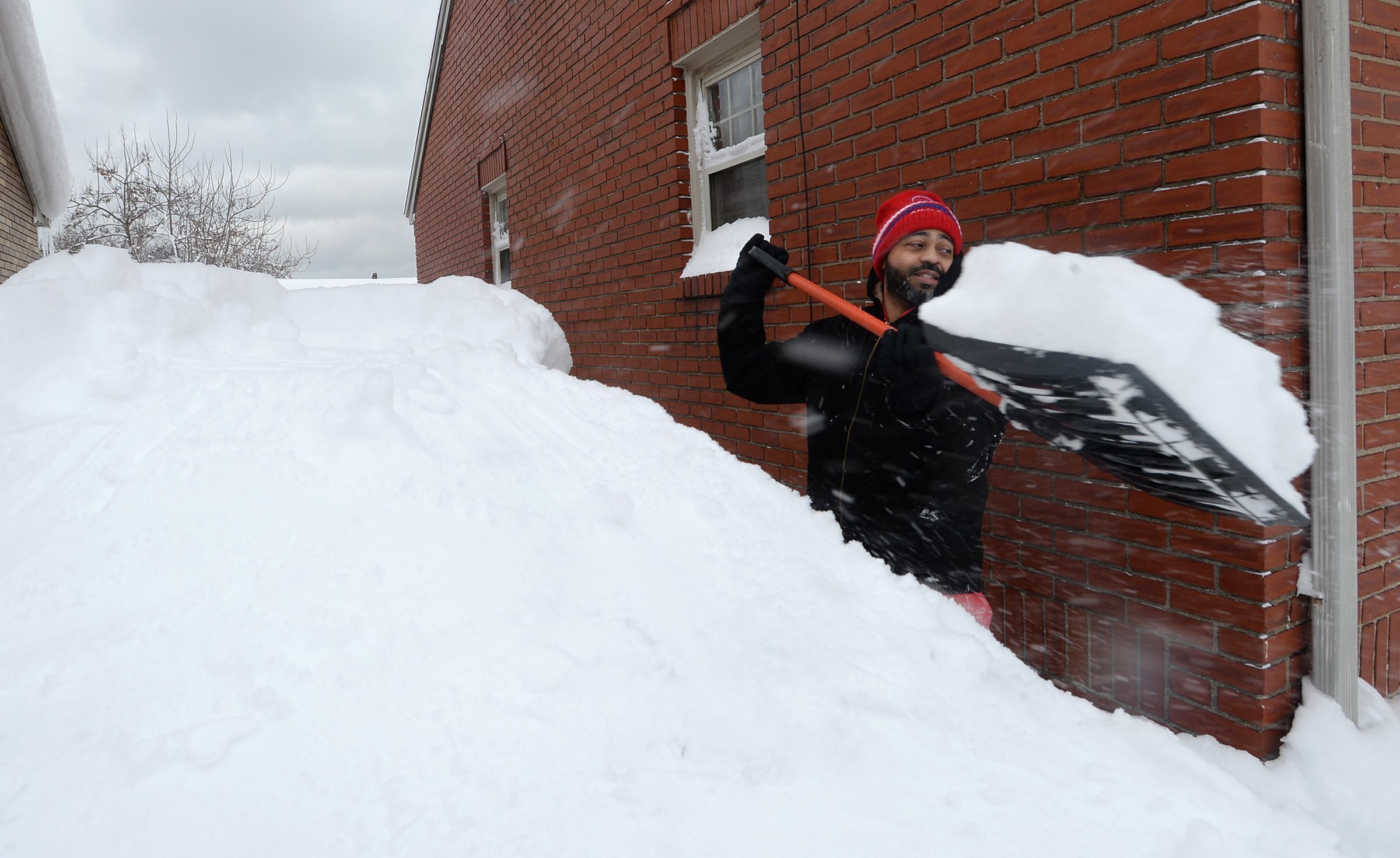 Patrick Harden clears snow from the roof of his car on Tuesday, Dec. 26, 2017, in Erie, Pa. The Nat...