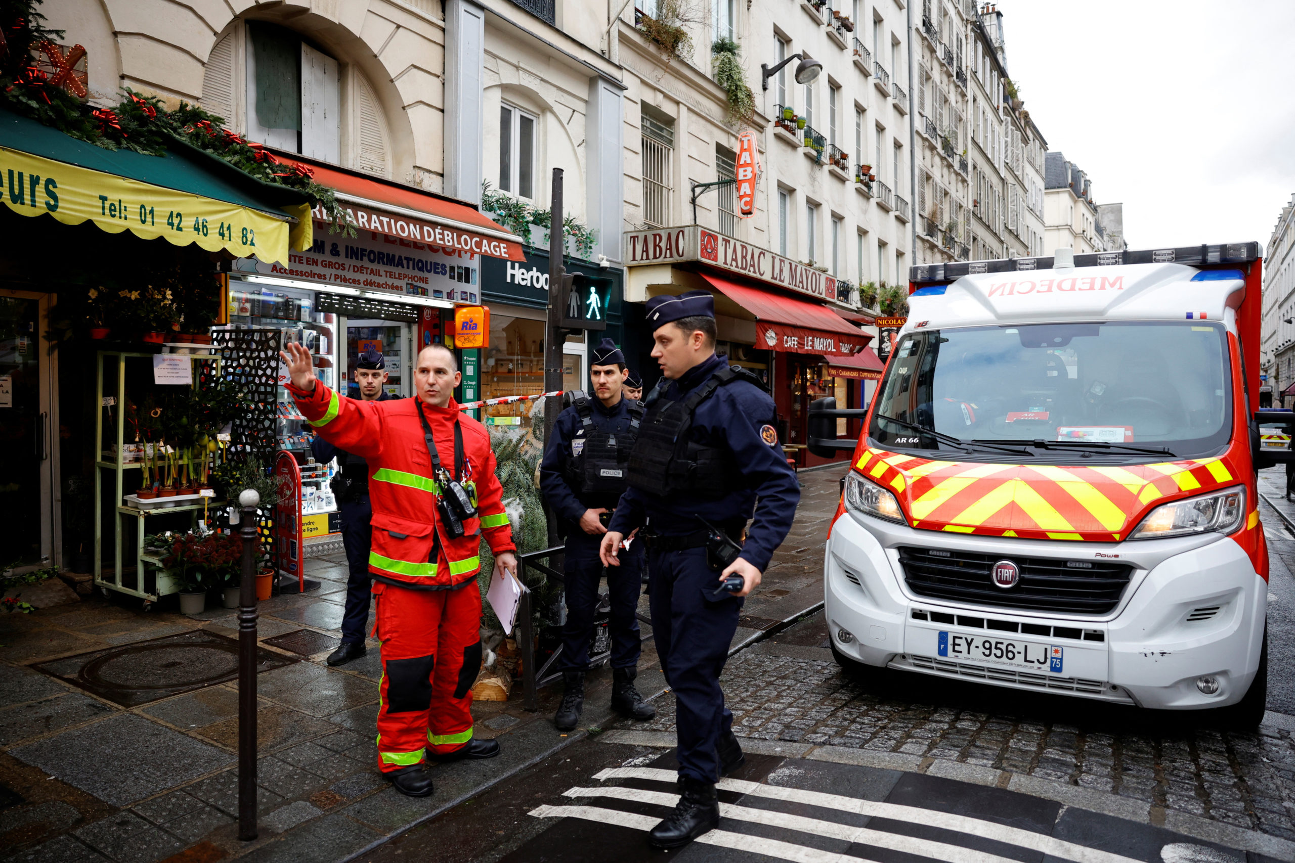 French police and firefighters secure a street after gunshots were fired killing two people and inj...