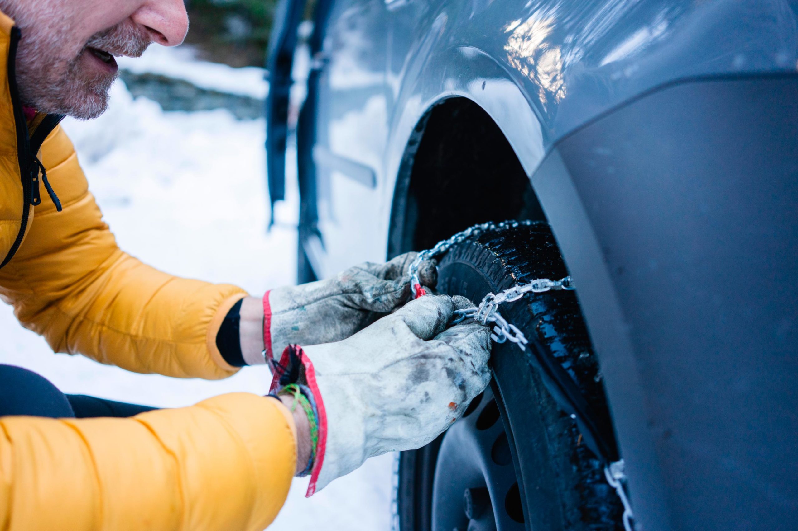 Man putting the snow chains on his car (Photo courtesy of Westend61, Getty Images)...