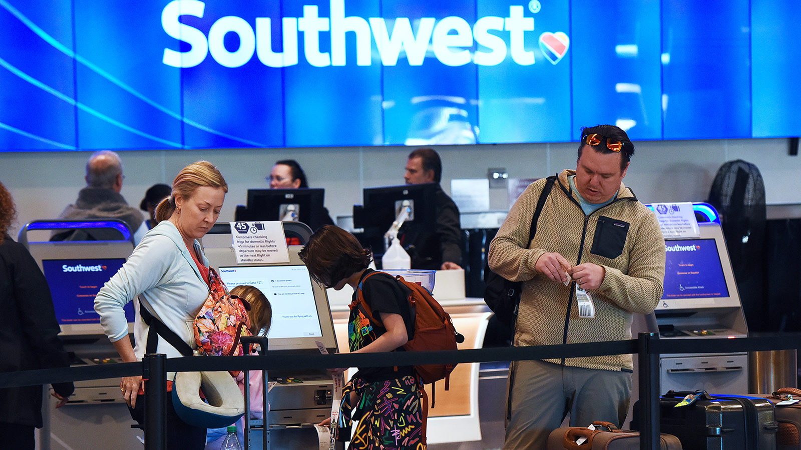Travelers tag their bags at a Southwest Airlines ticket counter during the busy Christmas holiday s...