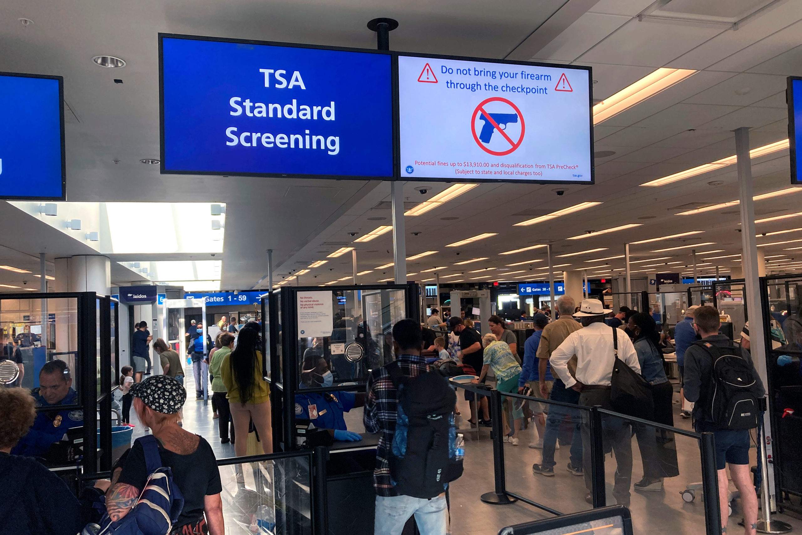 FILE - A sign warns travelers not to bring guns through the Transportation Security Administration ...
