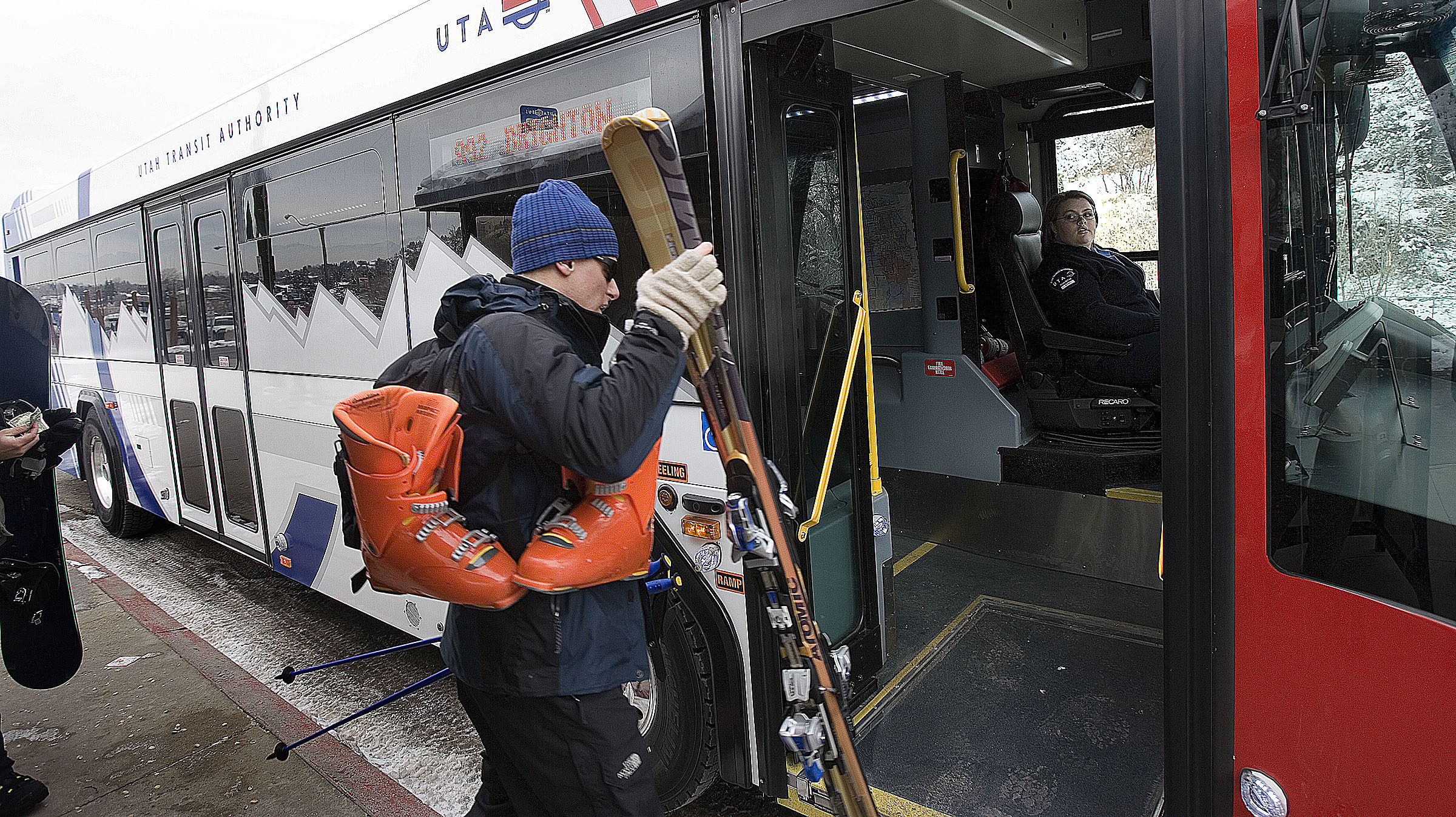 a man boards a ski bus with his gear...