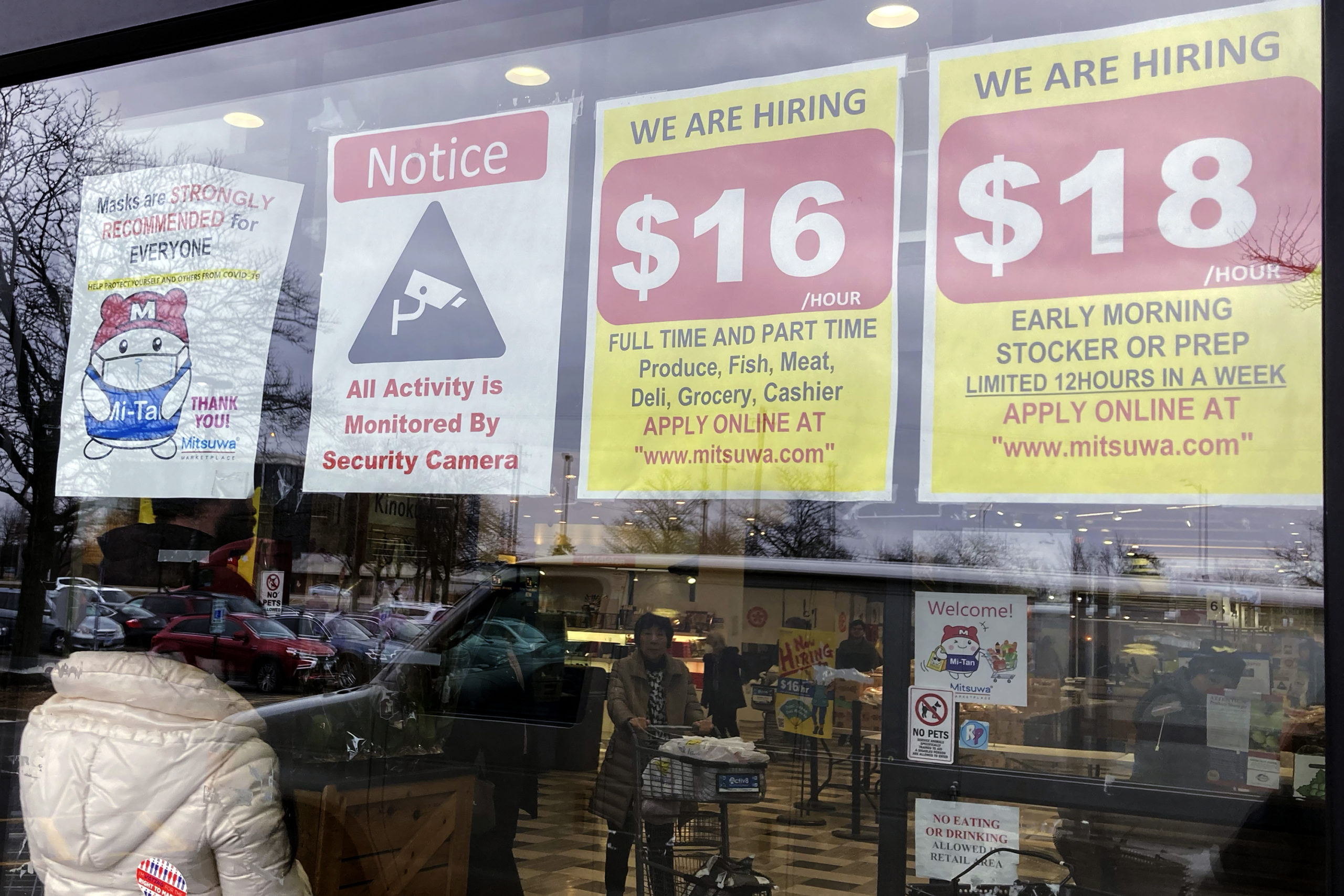 FILE - Hiring signs are displayed at a grocery store in Arlington Heights, Ill., Friday, Jan. 13, 2...