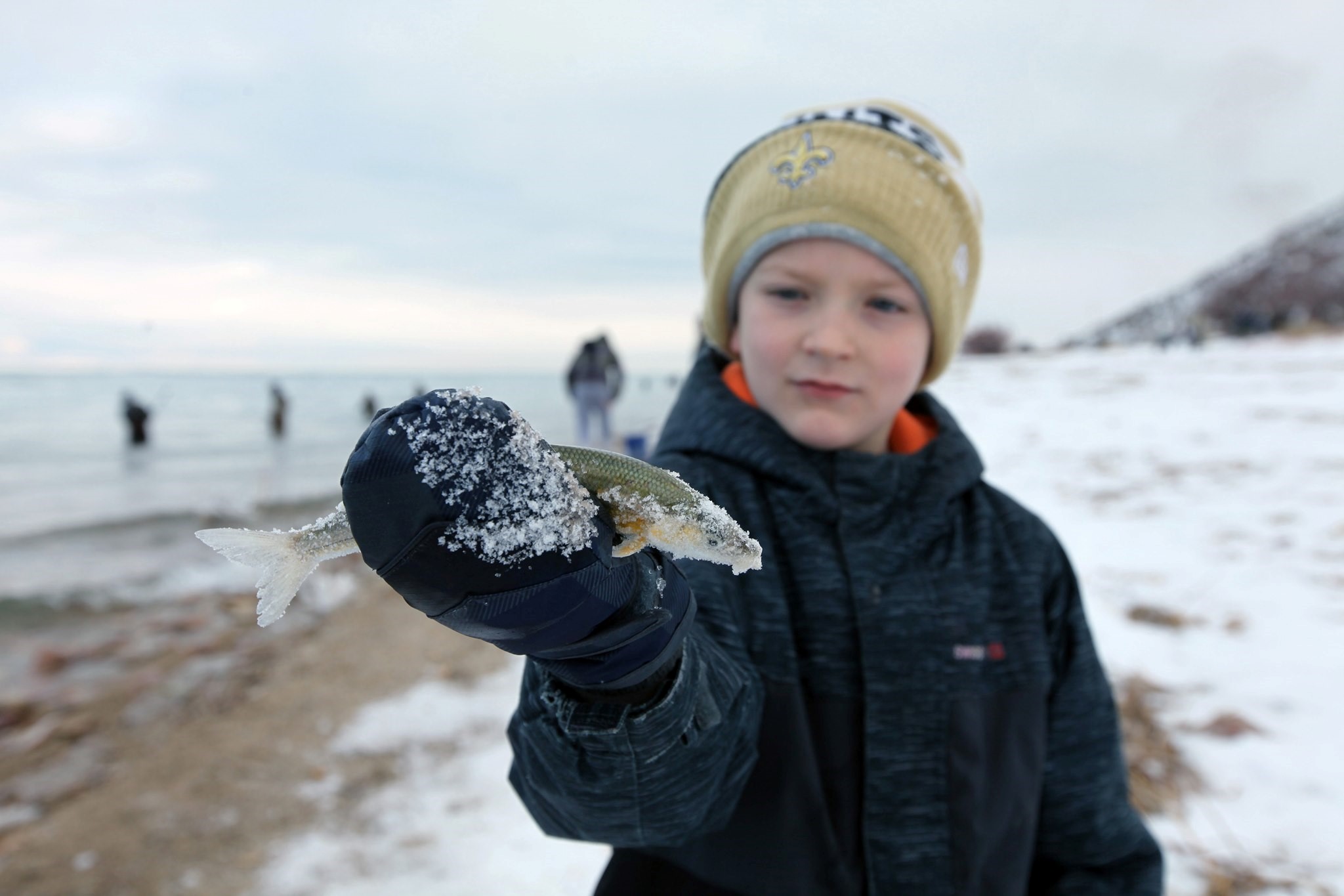 Kid holding a cisco fish at winterfest...