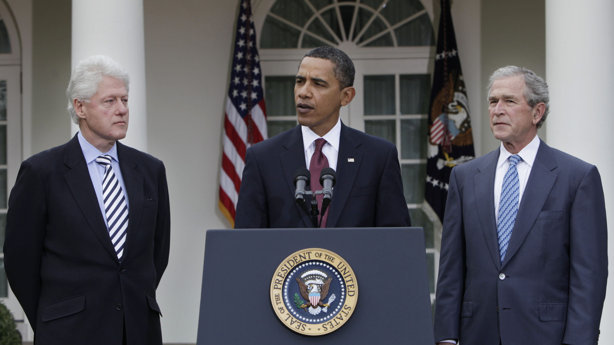 President Barack Obama (center) speaks as former Presidents Bill Clinton (left) and George W. Bush ...
