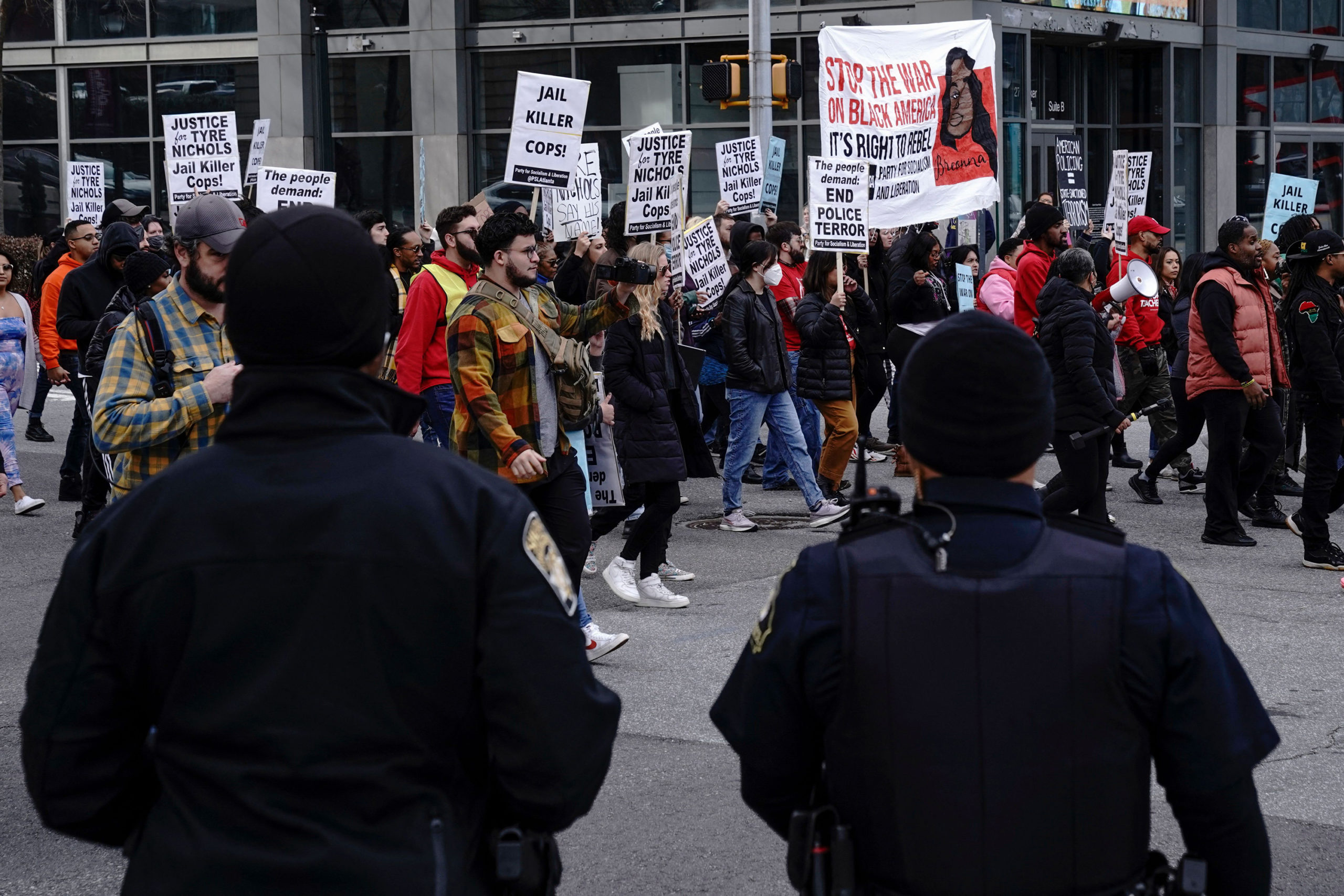 Atlanta Police Officers watch as protesters march during a rally against the fatal police assault o...