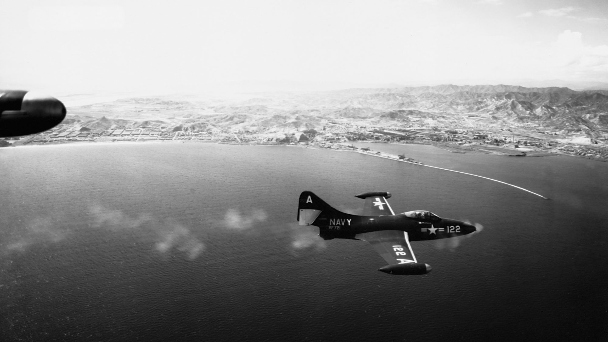 A Grumman F9F Panther fighter jet fires its guns during an attack on the North Korean port of Hungn...