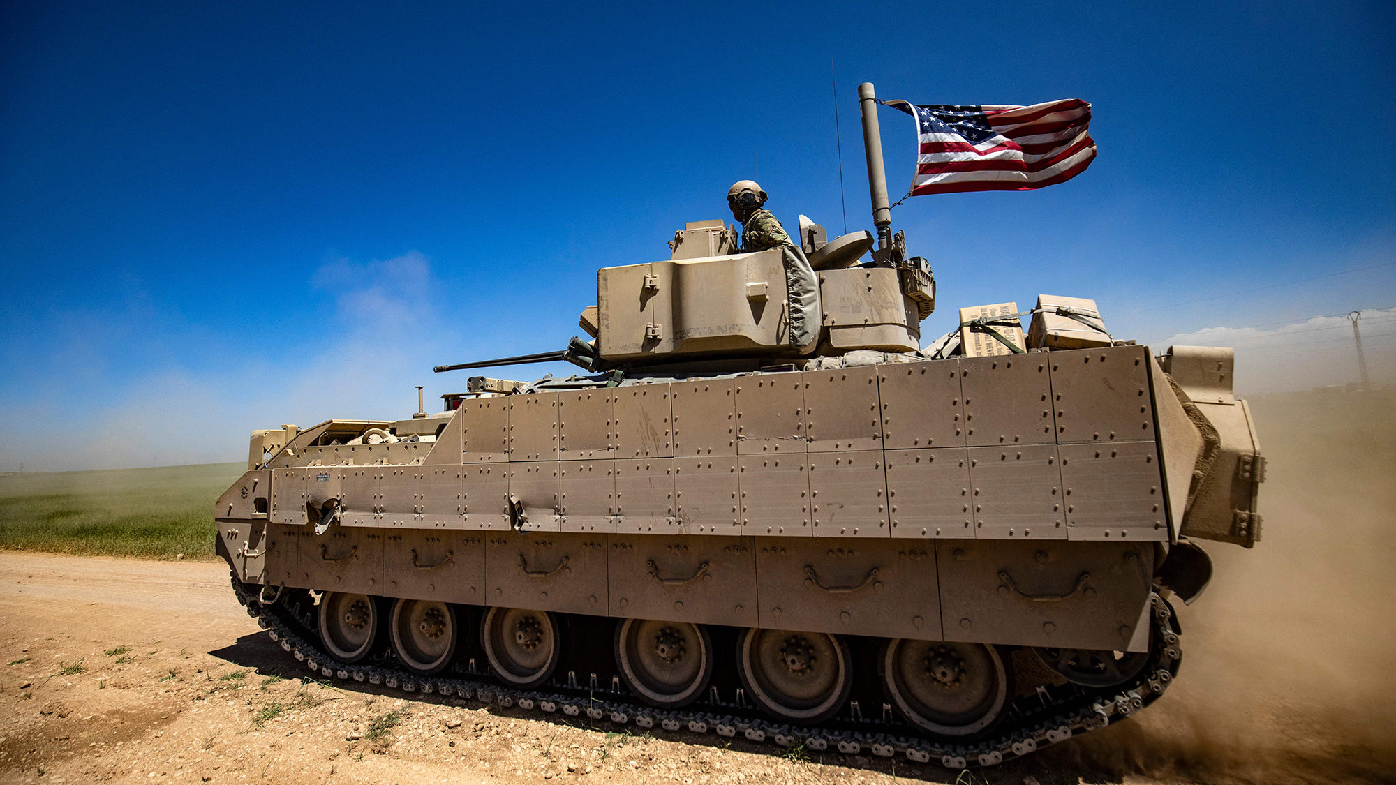 A US Bradley Fighting Vehicle patrols the countryside of the Kurdish-majority city of Qamishli in S...
