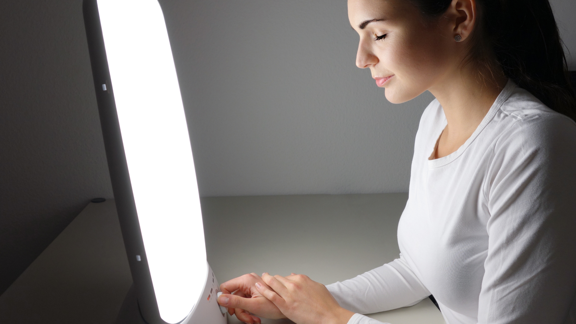 A woman wearing white sitting in front of a light box...