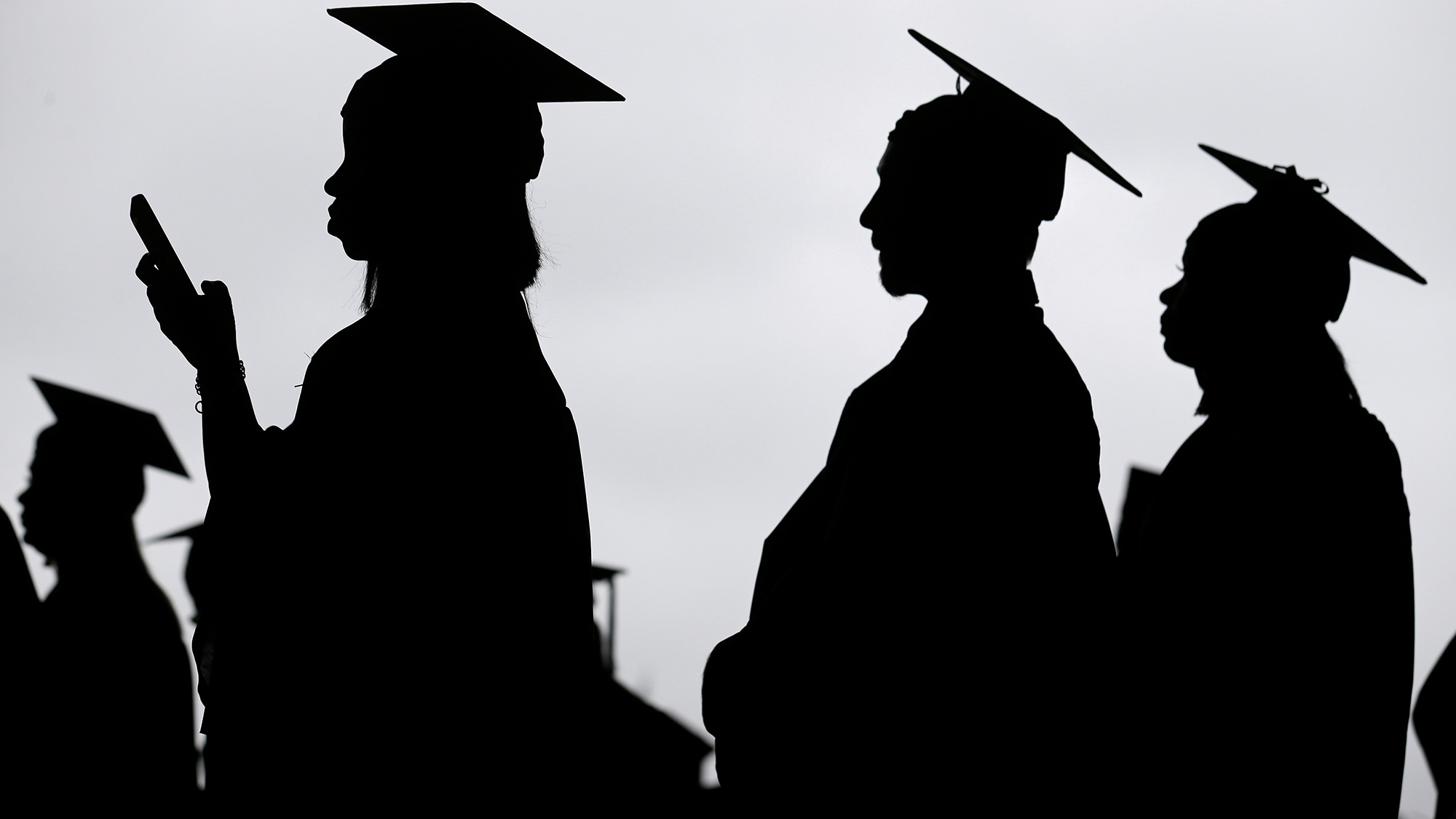 FILE - New graduates line up before the start of a community college commencement in East Rutherfor...