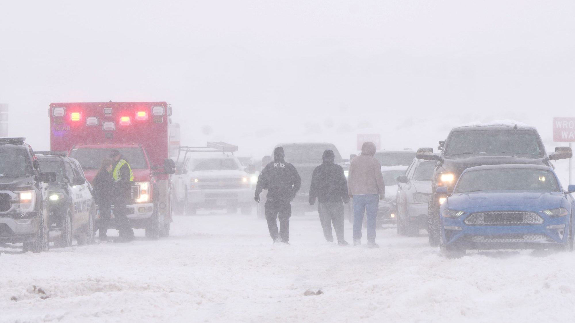 Police and emergency workers try to free vehicles from the snow on Mountain View Parkway in Lehi, U...