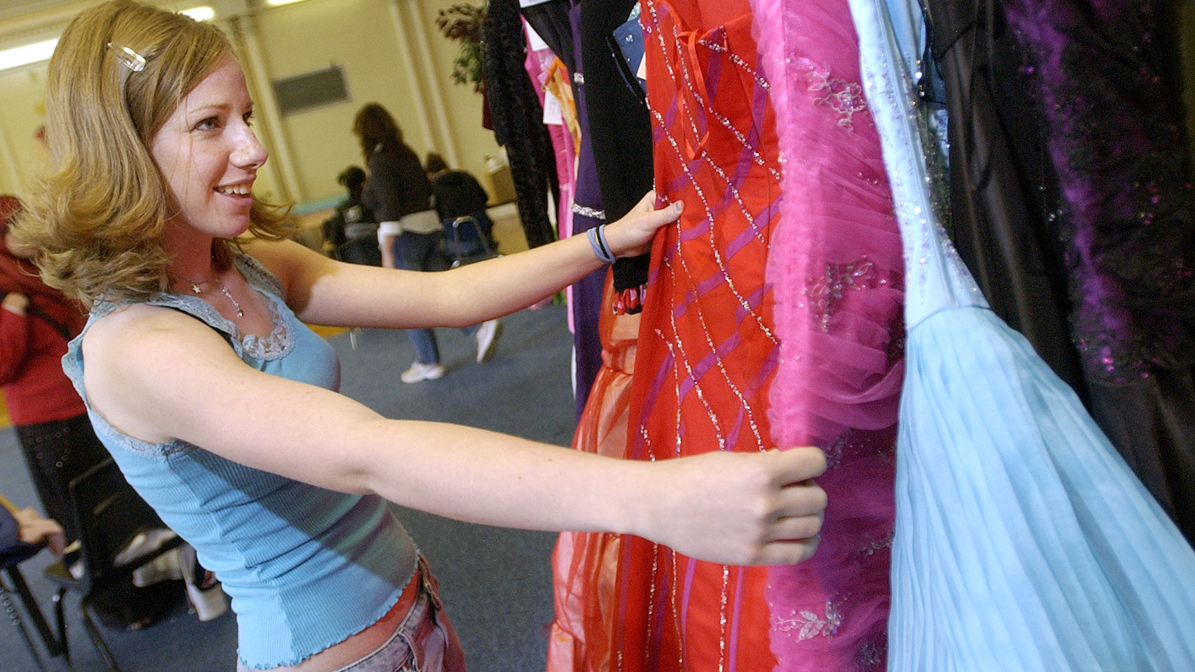 a teen is pictured looking at formal wear...