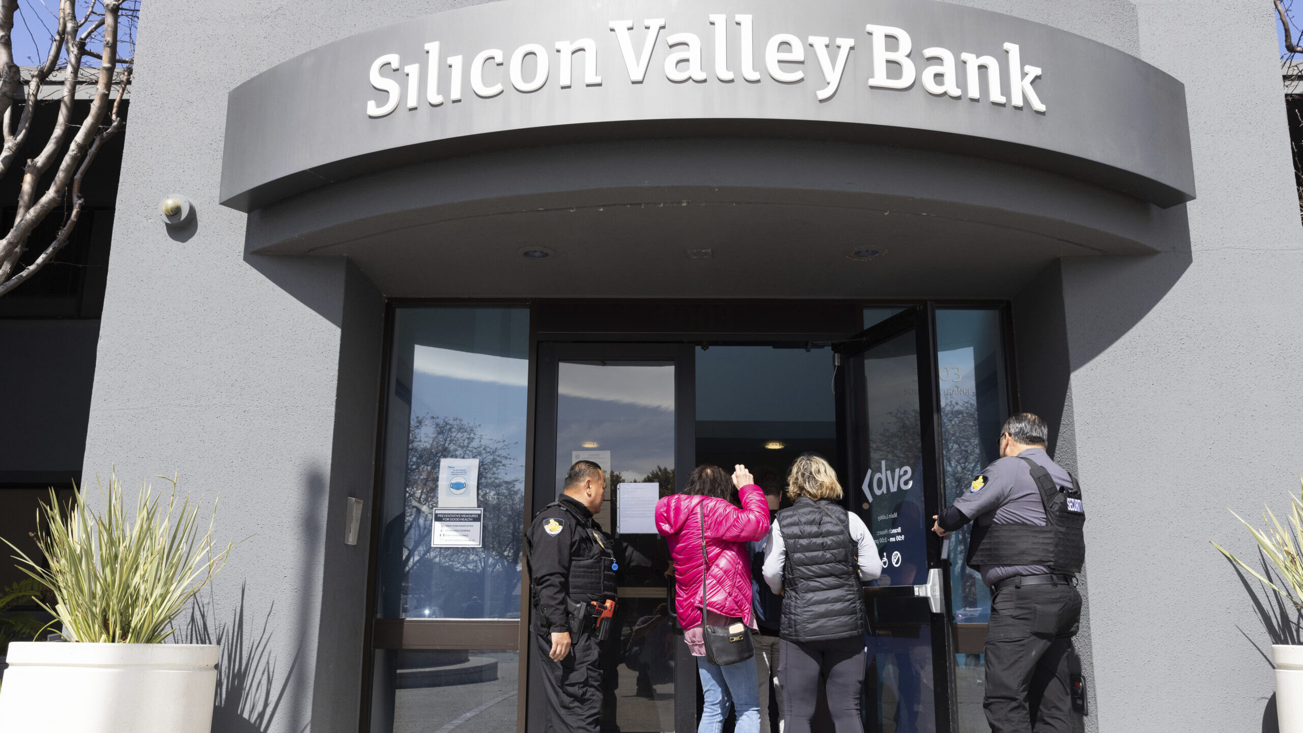 FILE - Security guards let individuals enter the Silicon Valley Bank's headquarters in Santa Clara,...