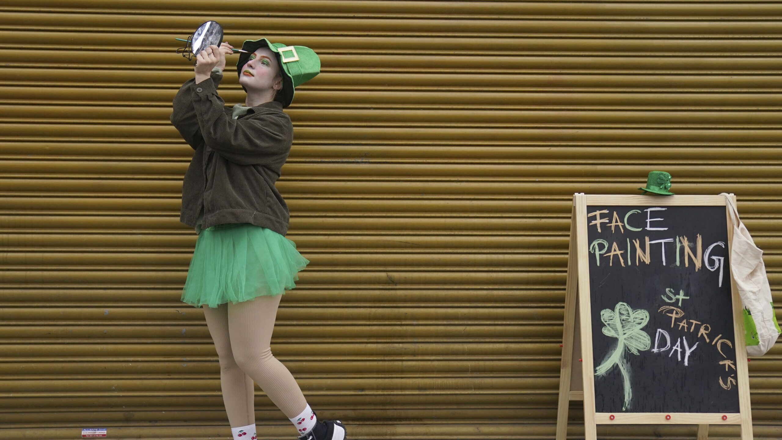 a girl in st patricks costume paints her face...