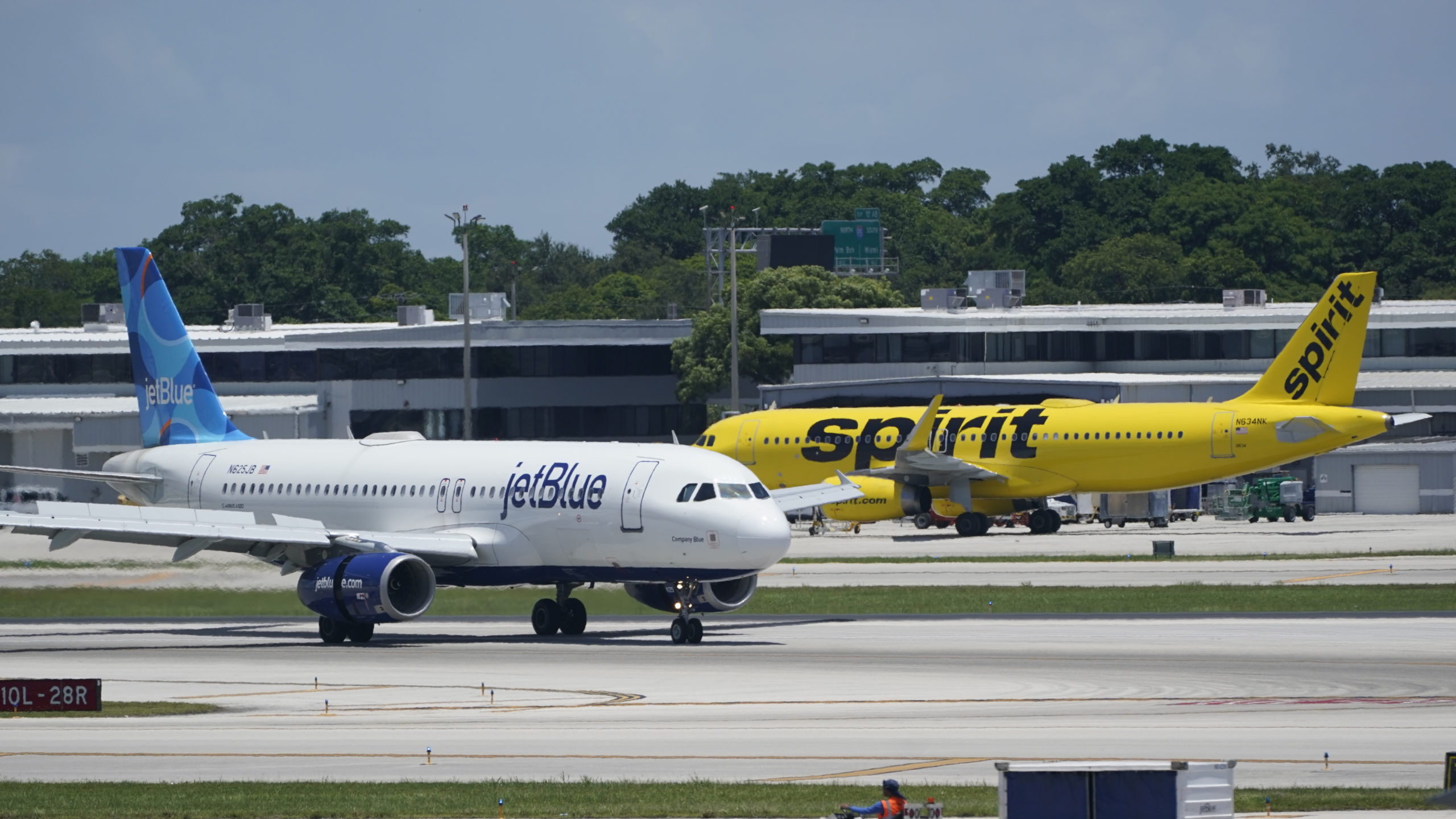 JetBlue and Spirit airplanes at an airport....