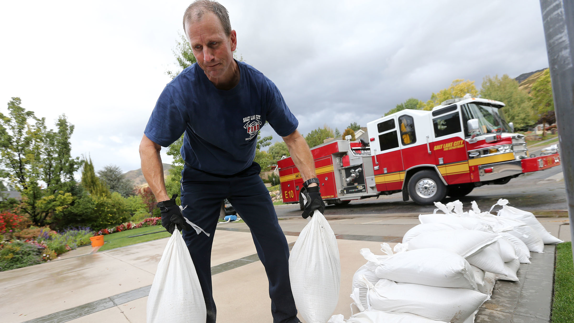 Salt Lake City fire engineer Craig Beckstrom moves sandbags while responding to flooding outside of...