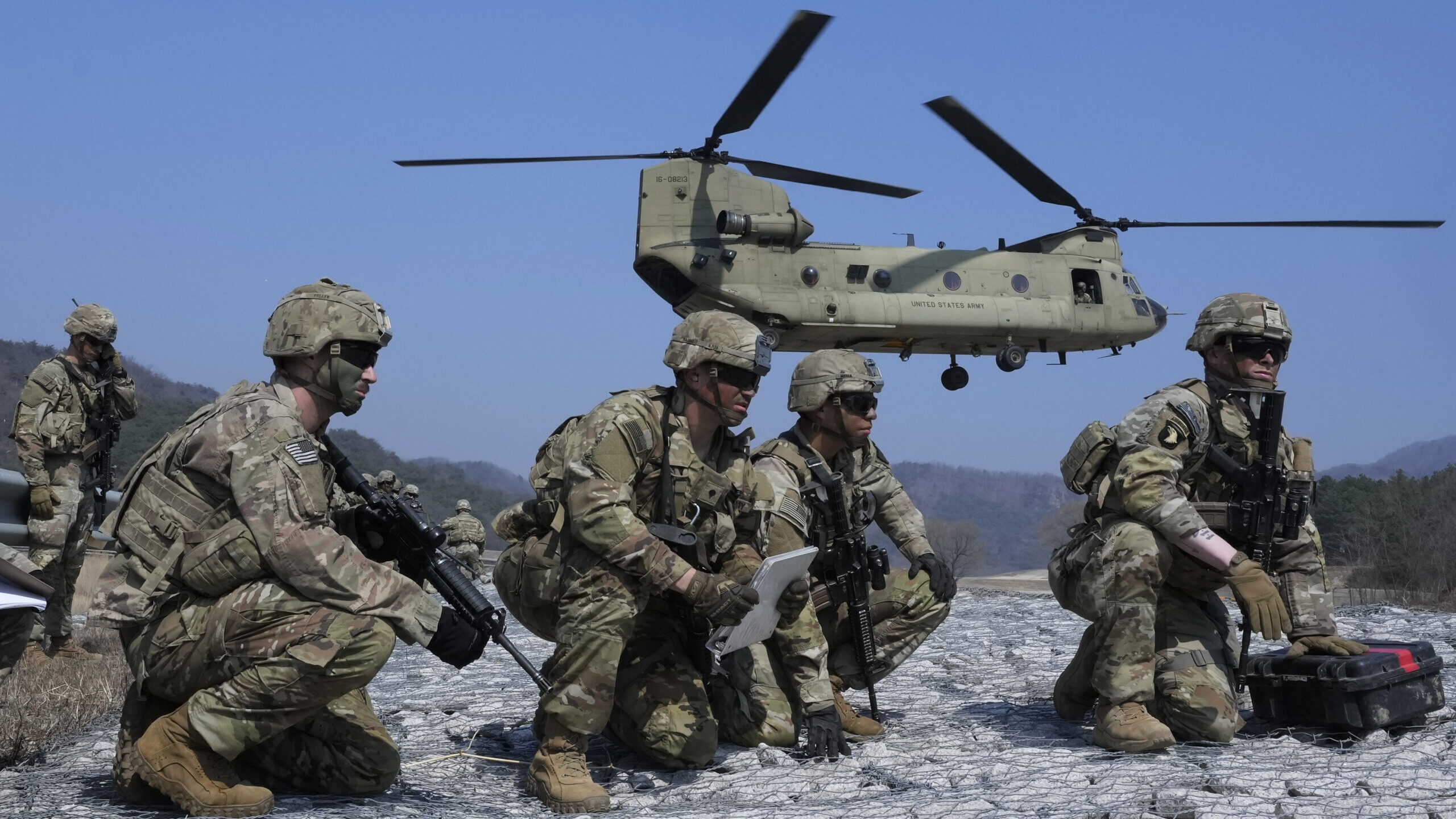 U.S. Army soldiers wait to board their CH-47 Chinook helicopter during a joint military drill betwe...