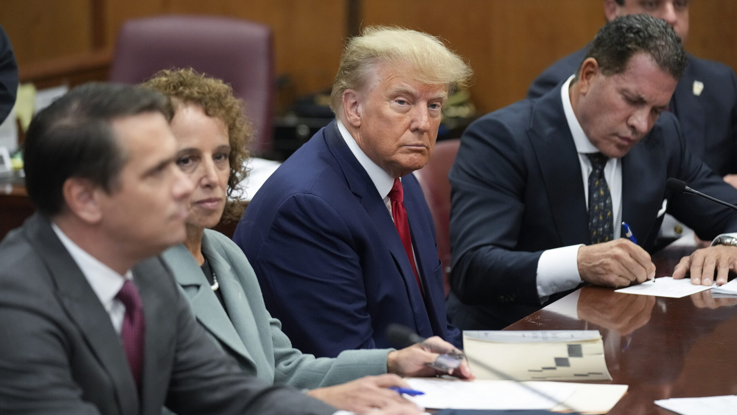 Former President Donald Trump sits at the defense table with his defense team in a Manhattan court,...