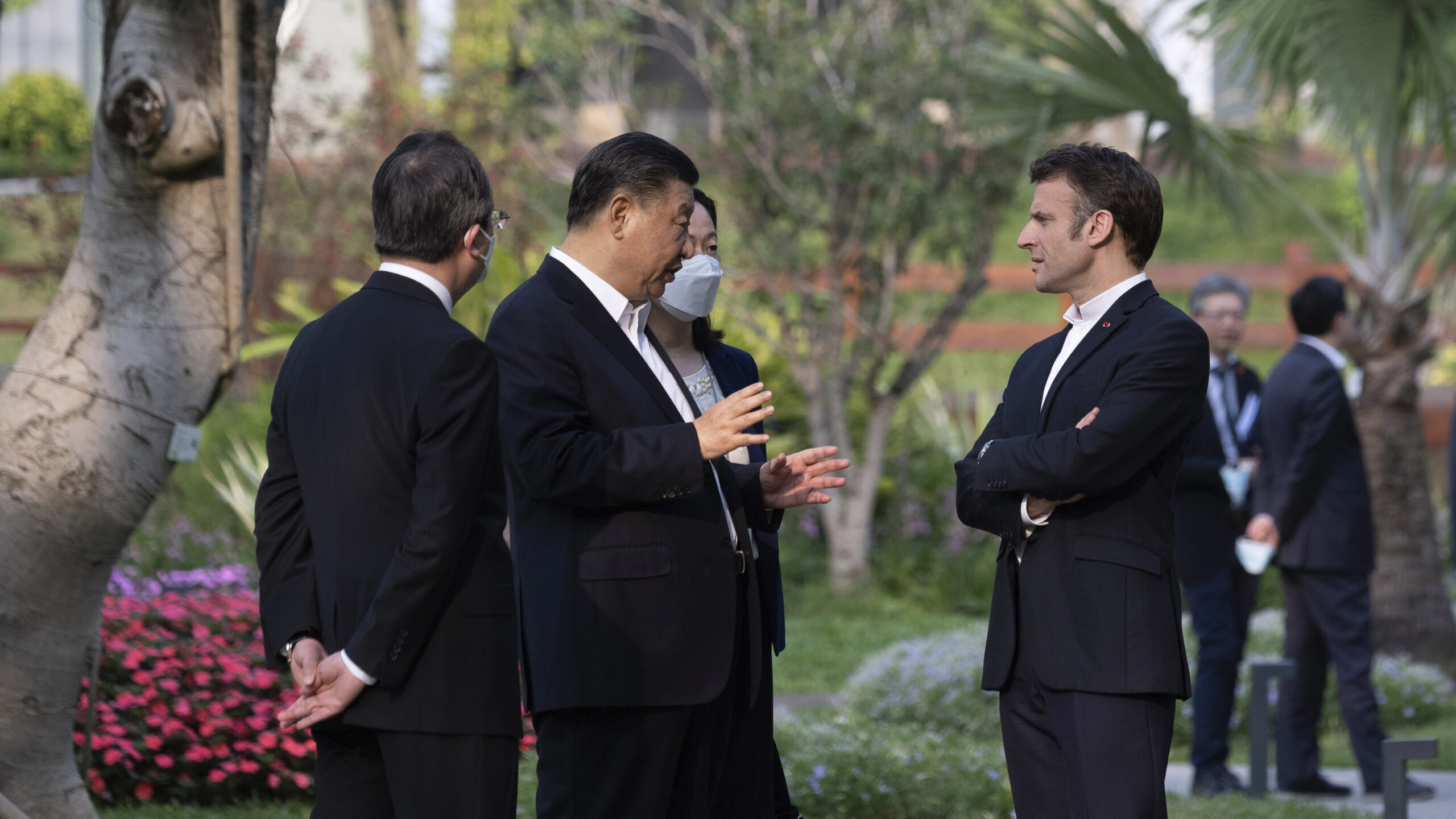 Chinese President Xi Jinping, second left, and French President Emmanuel Macron talk in the garden ...