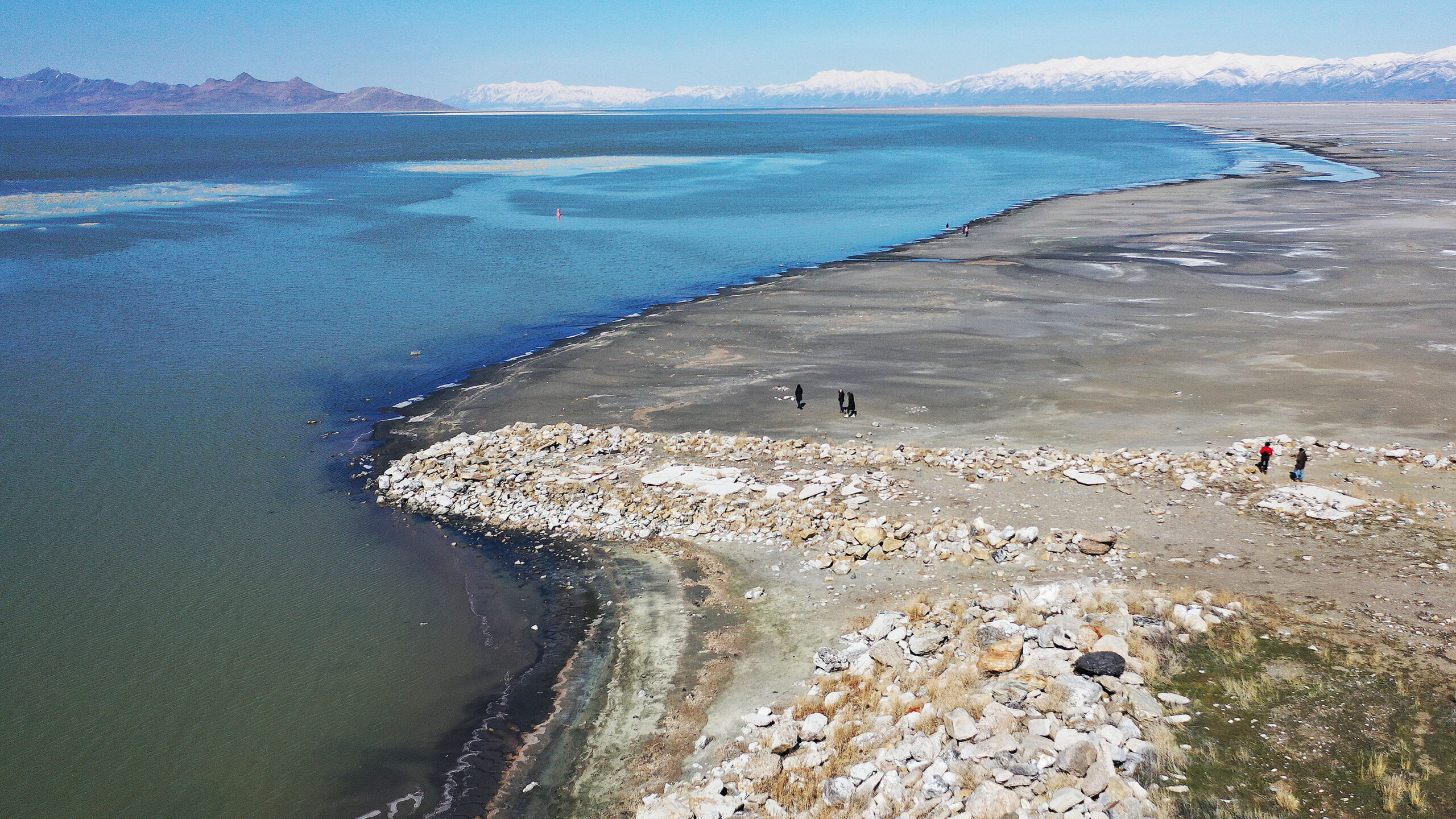 the great salt lake is pictured as people walk along it...