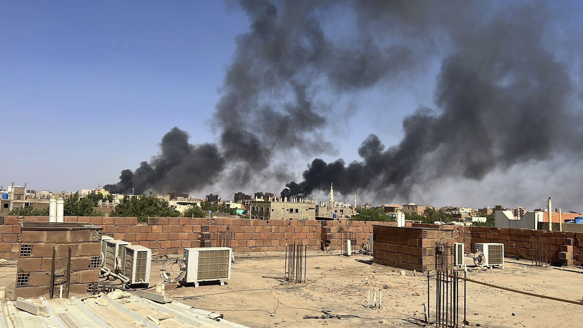 In this photo provided by Maheen S, smoke fills the sky in Khartoum, Sudan, near Doha International...