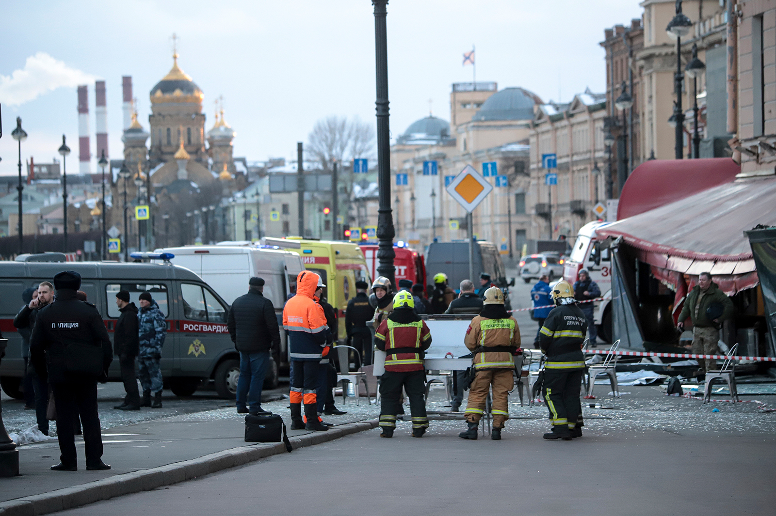 Emergency service workers stand at the site of the blast at the St. Petersburg cafe on Sunday. Russ...