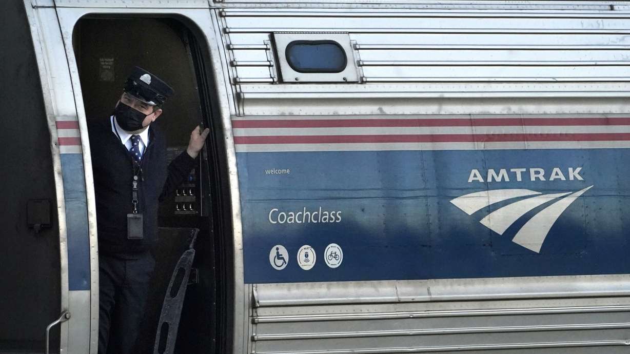 A conductor makes sure all is clear as the Amtrak Downeaster passenger train pulls out of the stati...