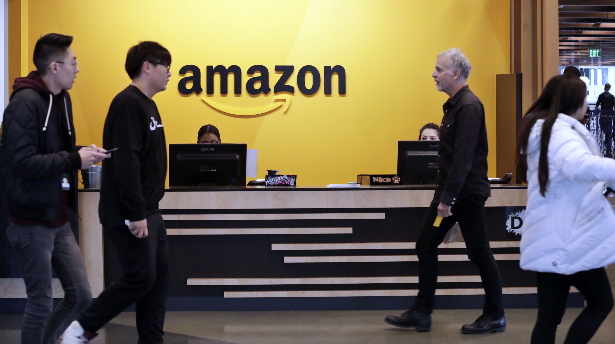 FILE - Employees walk through a lobby at Amazon's headquarters on Nov. 13, 2018, in Seattle. Amazon...