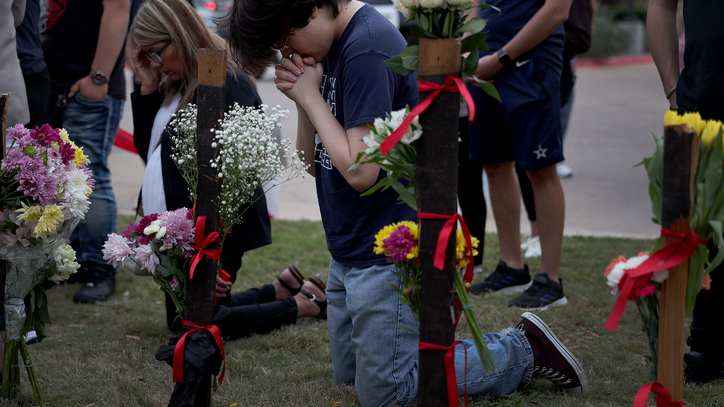 Carson Smith prays Sunday at a memorial next to Allen Premium Outlets. Photo credit: Joe Raedle/Get...