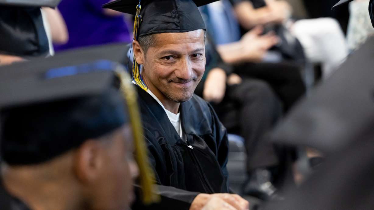 Jose Rios-Mojica gets a fist-bump from a fellow graduate after giving an address at a commencement ...