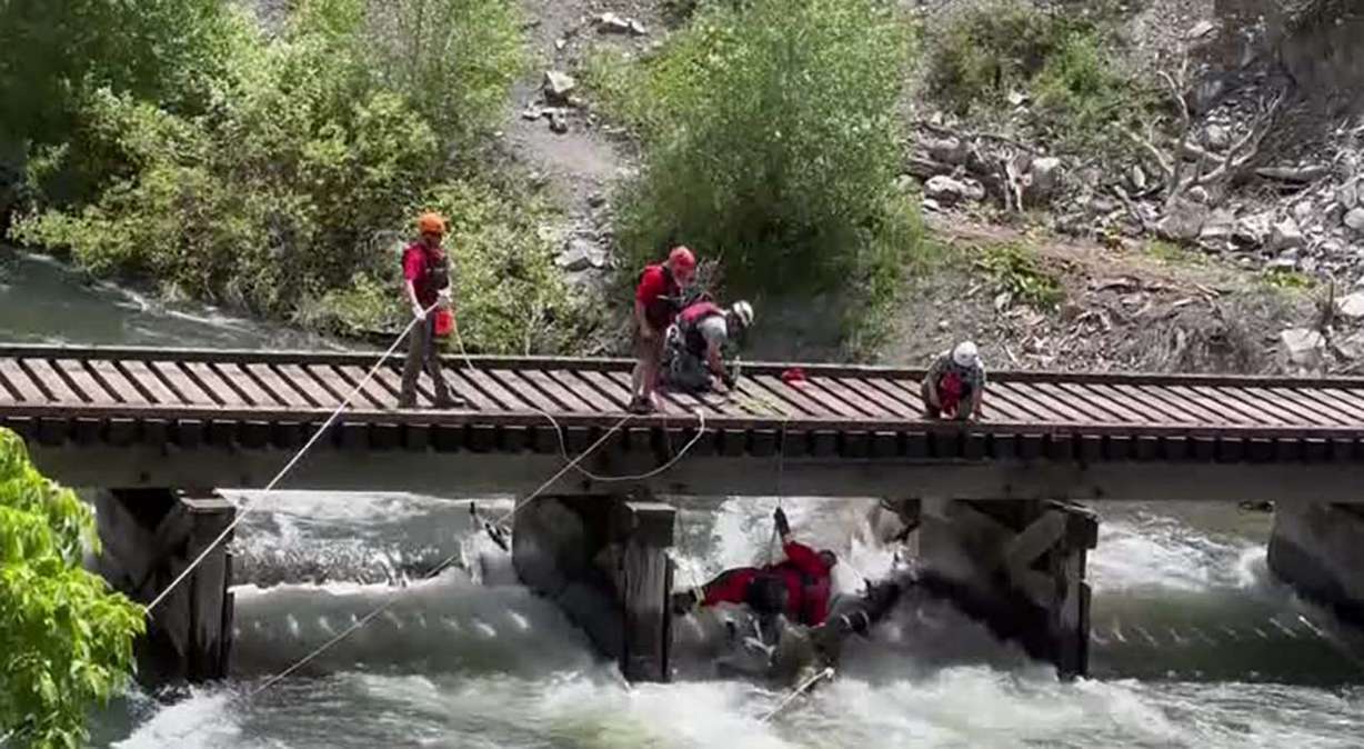 Crews work to clear debris, including a large log, from the Provo River Tuesday. Some people are ig...