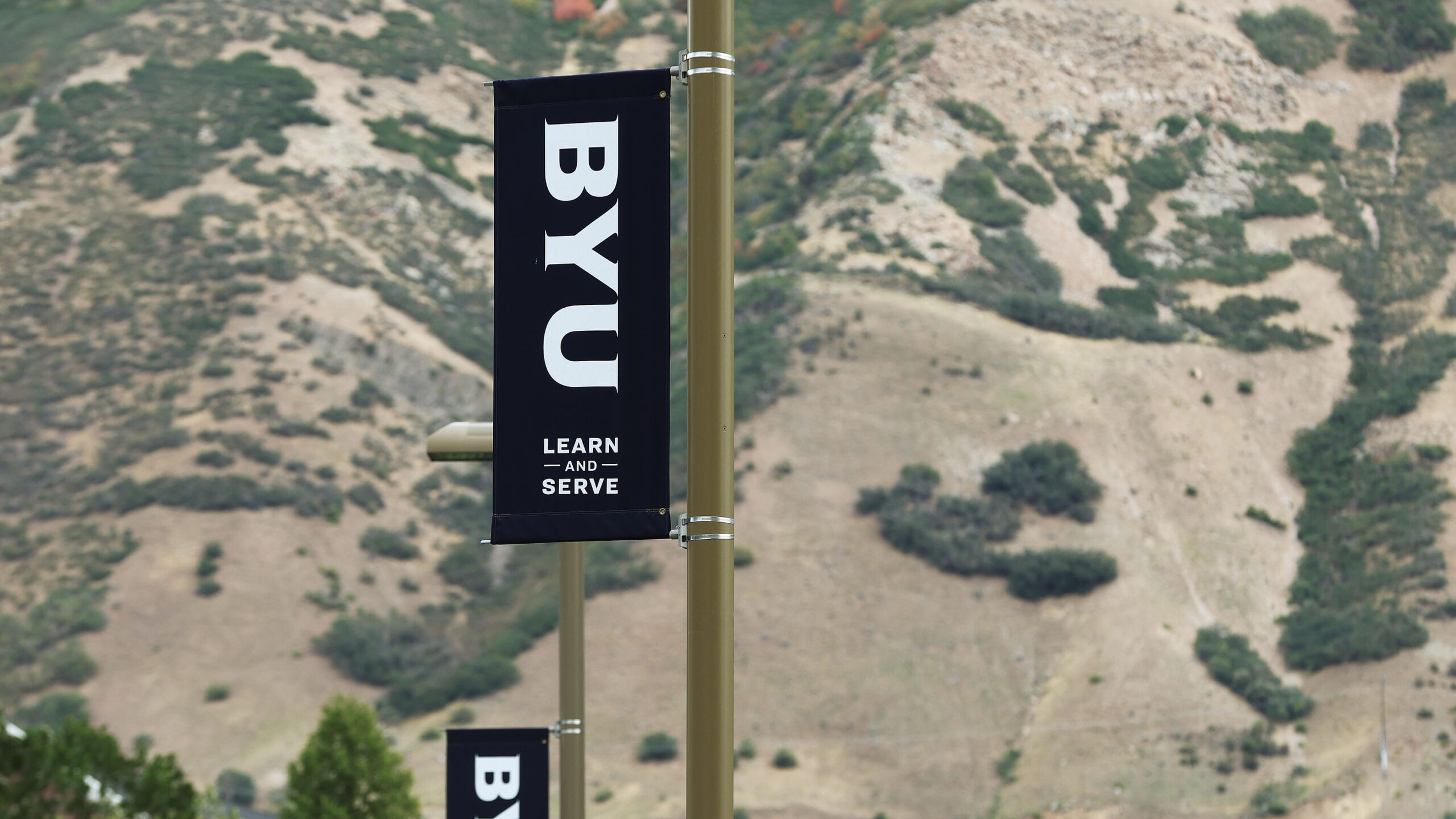 a sign on a pole says byu, learn and serve, the school is offering a new machine learning degree...