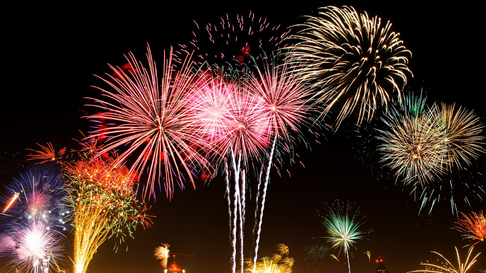 Fireworks explode over a city in celebration....