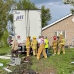 Two injured when semi-truck crashes through garages of complex, hits propane tank
