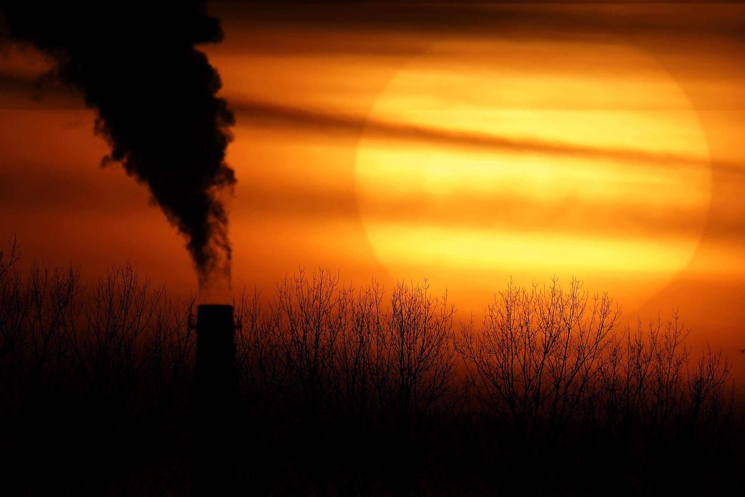 FILE - Emissions from a coal-fired power plant are silhouetted against the setting sun in Kansas Ci...