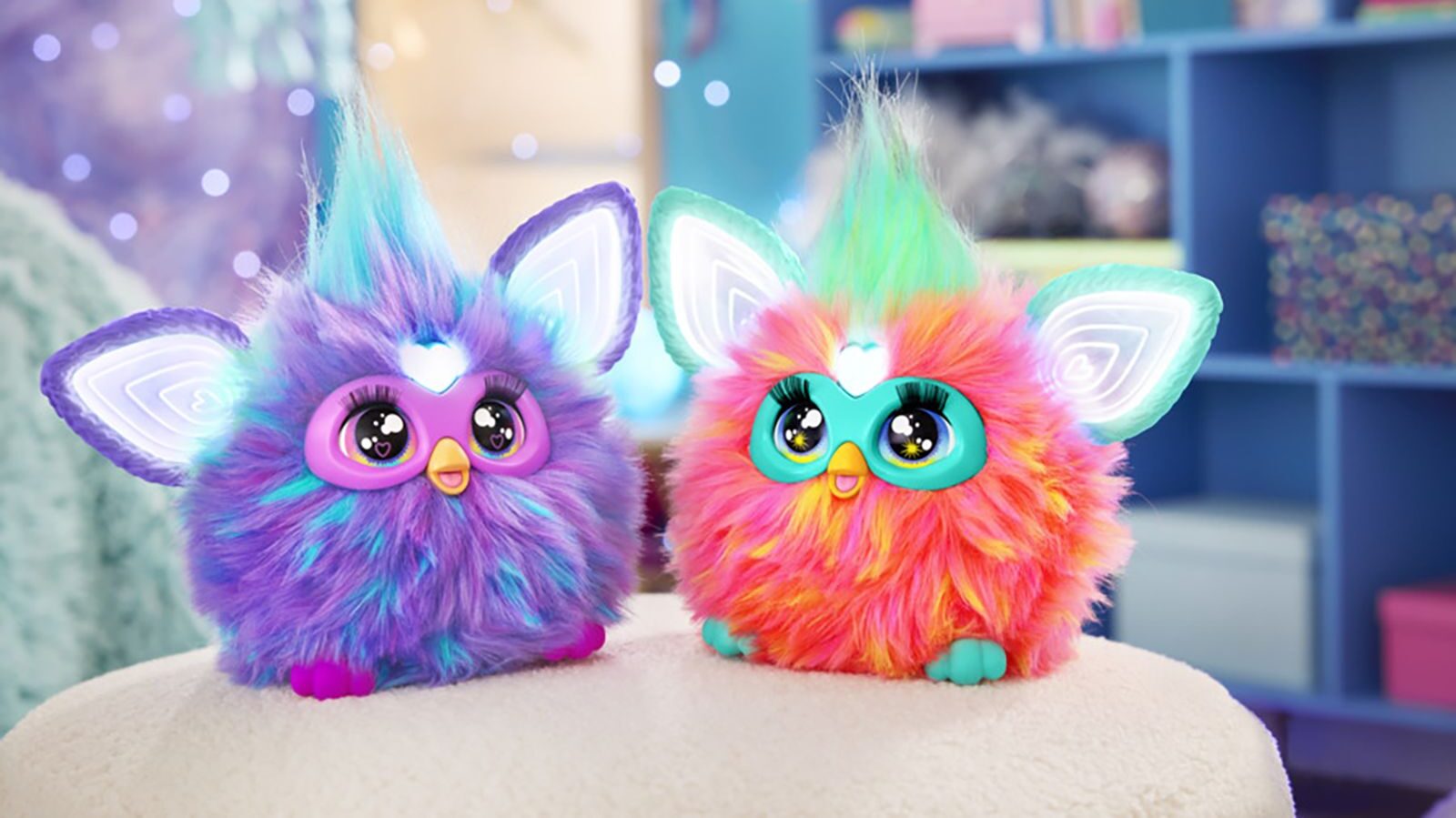 a furby toy pair is pictured, one pink and one purple...