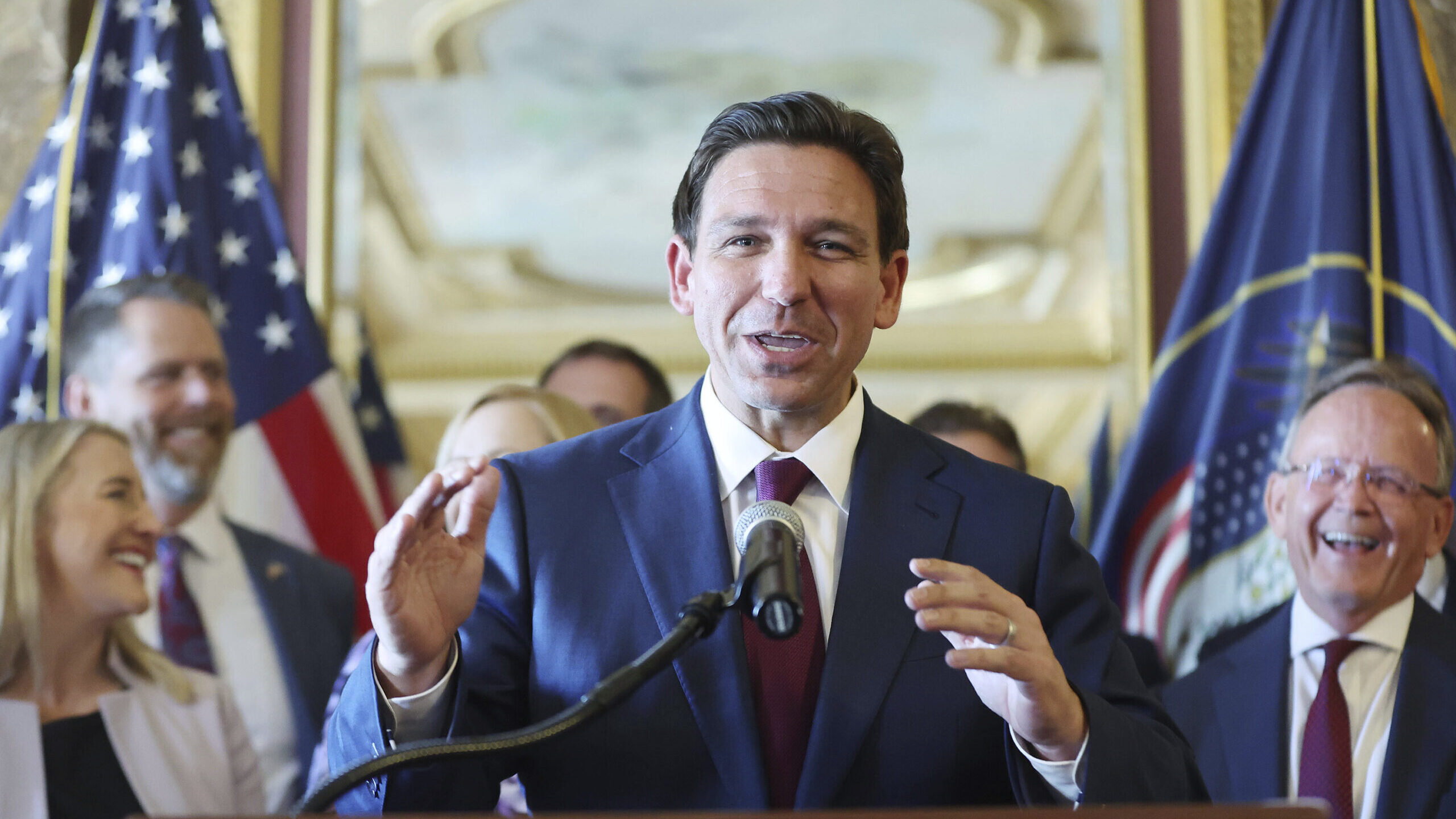 gov ron desantis speaks at a podium, utah lawmakers have responded to the governors stance on educa...