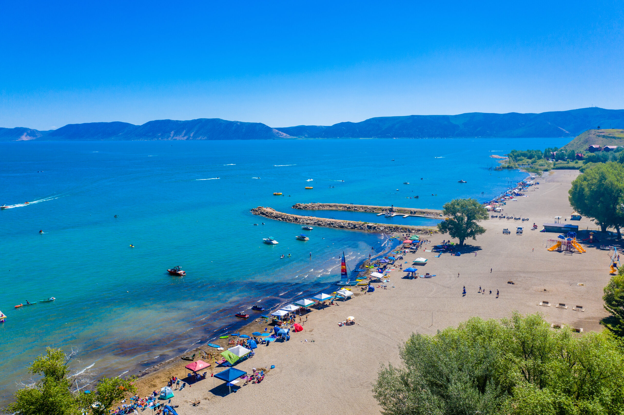 Aerial photo of Bear Lake shoreline with canopies and people camped out on the beach...
