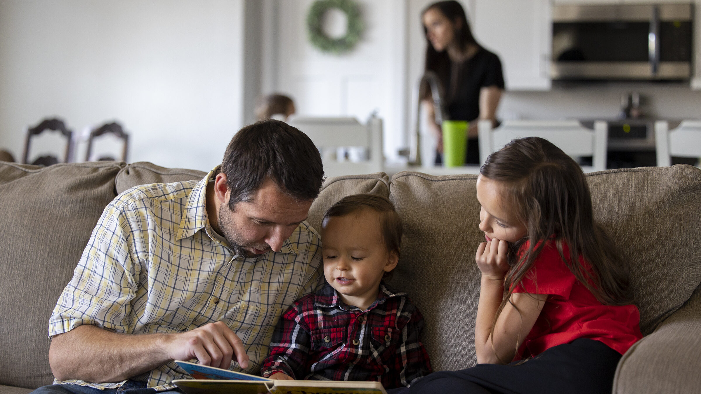 Father reads a book with son and daughter at their home in Provo on Wednesday, April 28, 2021....