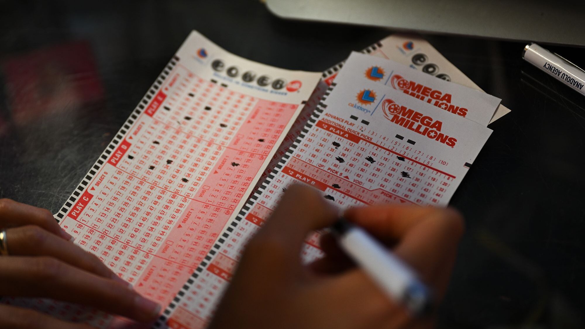 A person plays lottery at a store as US Powerball jackpot grand prize grew to a whopping $1 billion...
