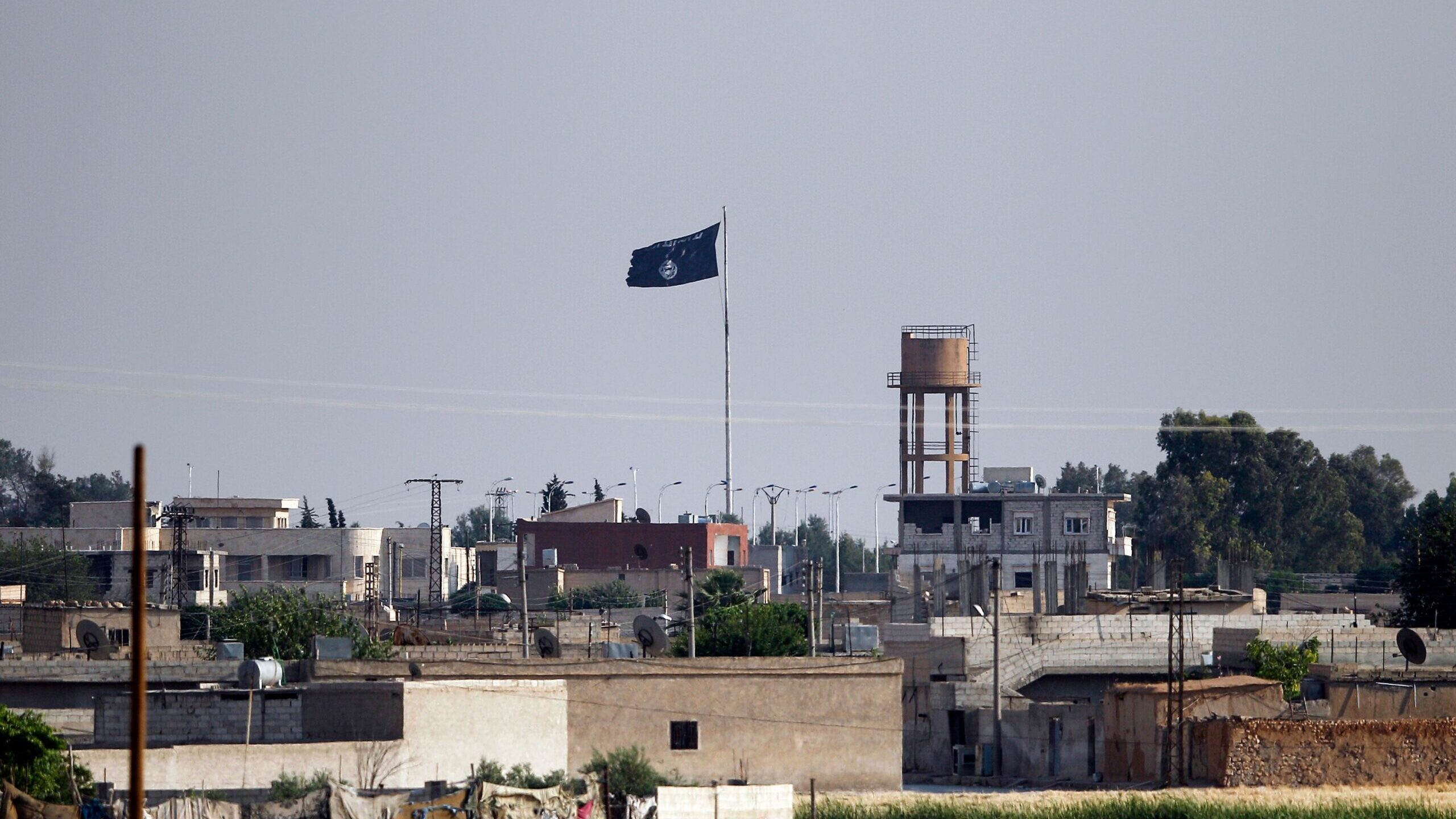 An ISIS flag flies in the northern Syrian town of Tel Abyad as seen from the Turkish border town of...