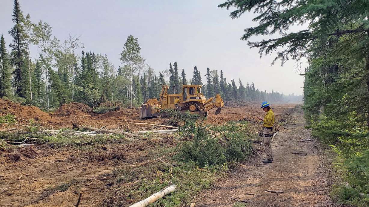 Firefighters work on a fuel break south of Anderson, Alaska, on Monday. Three Orem firefighters wer...