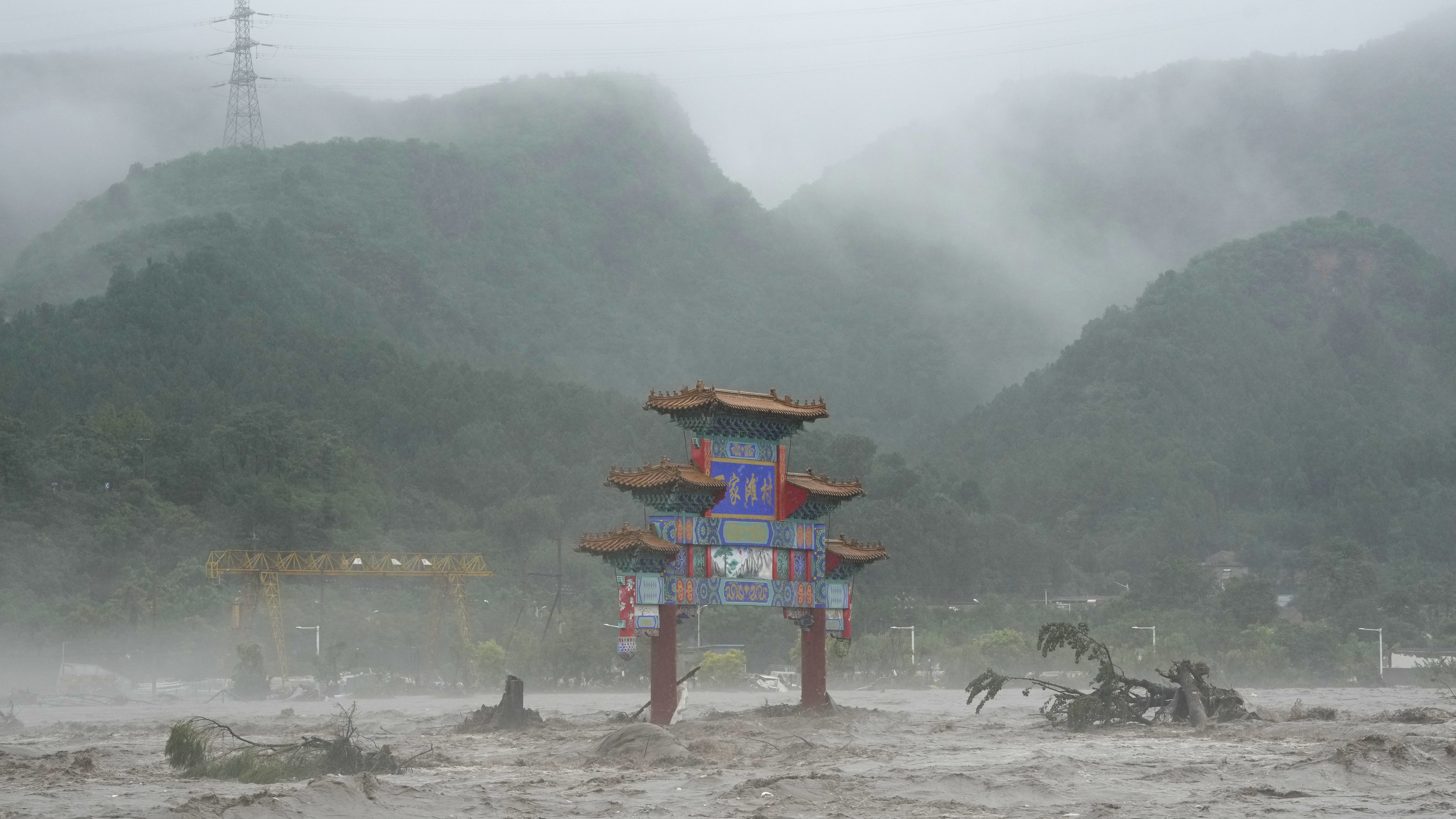 A traditional gate is seen inundated by flood waters in the Miaofengshan area on the outskirts of B...