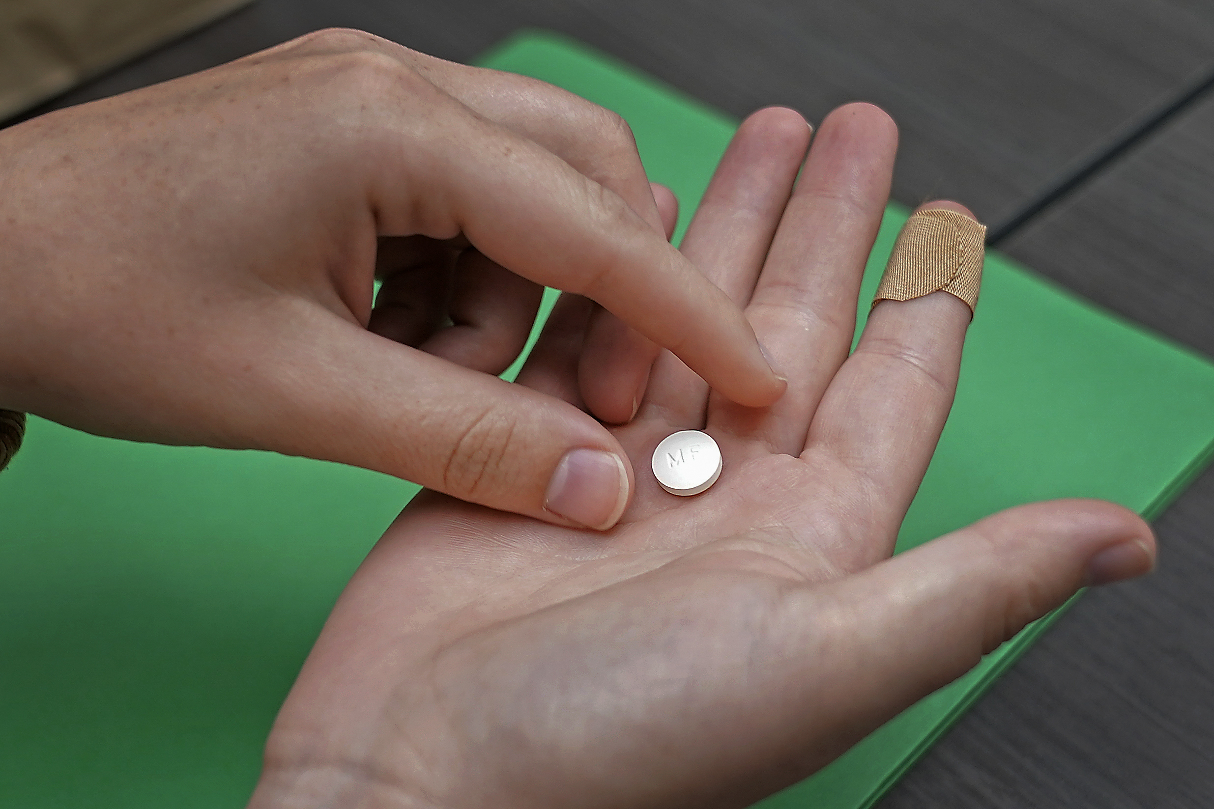Image of a hand holding a pill. New restrictions on access to the drug used in the most common form...