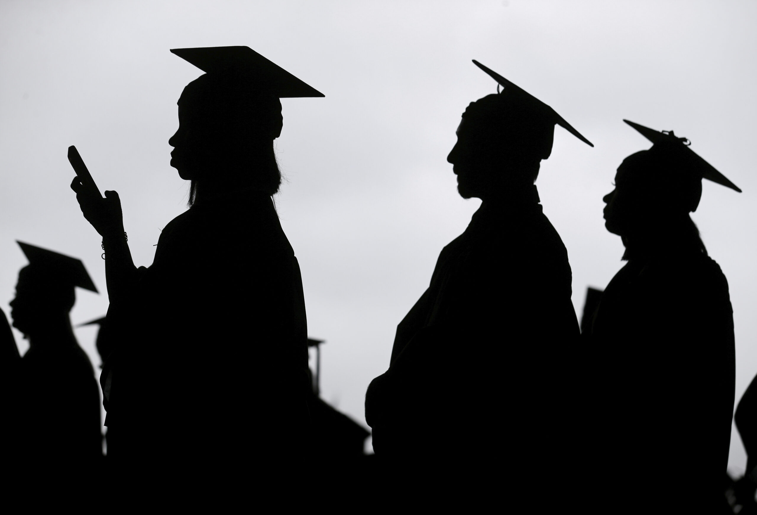 FILE - New graduates line up before the start of a community college commencement in East Rutherfor...